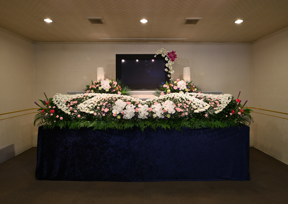 メモリーが大仙市のホールで祭壇と白中心の生花アレンジを飾った葬儀会場