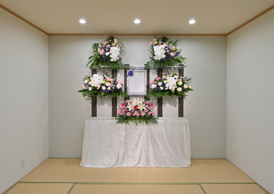 メモリーが大仙市のホールで花祭壇を飾り遺族が見守る和室風の葬儀場